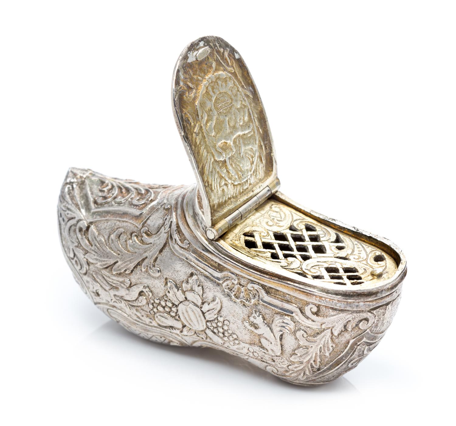 A German Silver Vinaigrette, Maker's Mark Obscured, in the form of a shoe, the exterior chased with floral, foliate and fauna decoratio
