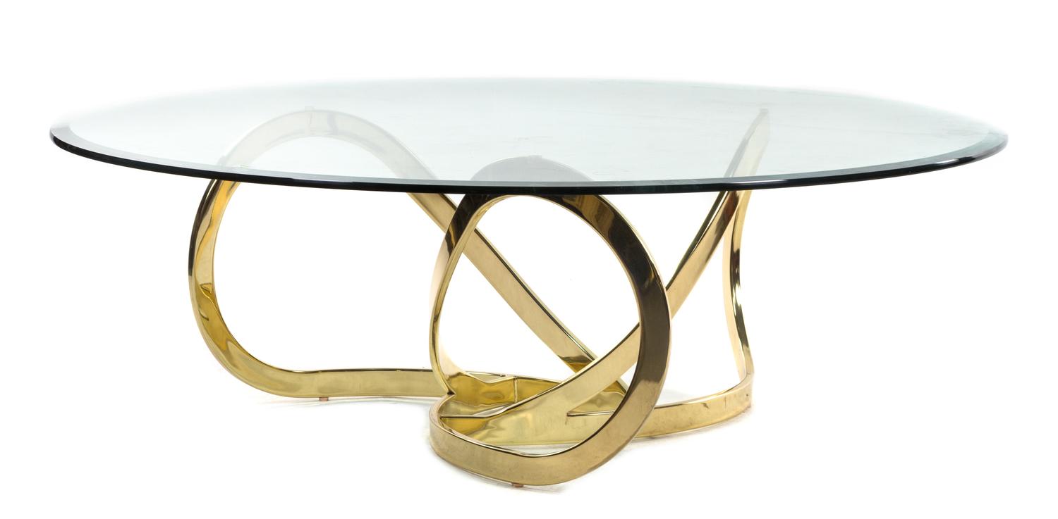 A Brass and Glass Coffee Table Height 15 3/4 x diameter 48 inches. — STYLE OF MILO BAUGHMAN