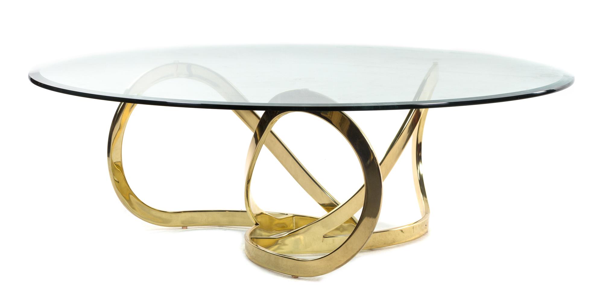 A Brass and Glass Coffee Table Height 15 3/4 x diameter 48 inches. — STYLE OF MILO BAUGHMAN
