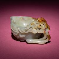 A Chinese Russet and Celadon Jade ‘Magpie and Plum Blossoms’ Peach-Form Coupe, 19th Century — 清晚期 青白玉帶皮喜上眉梢桃形杯