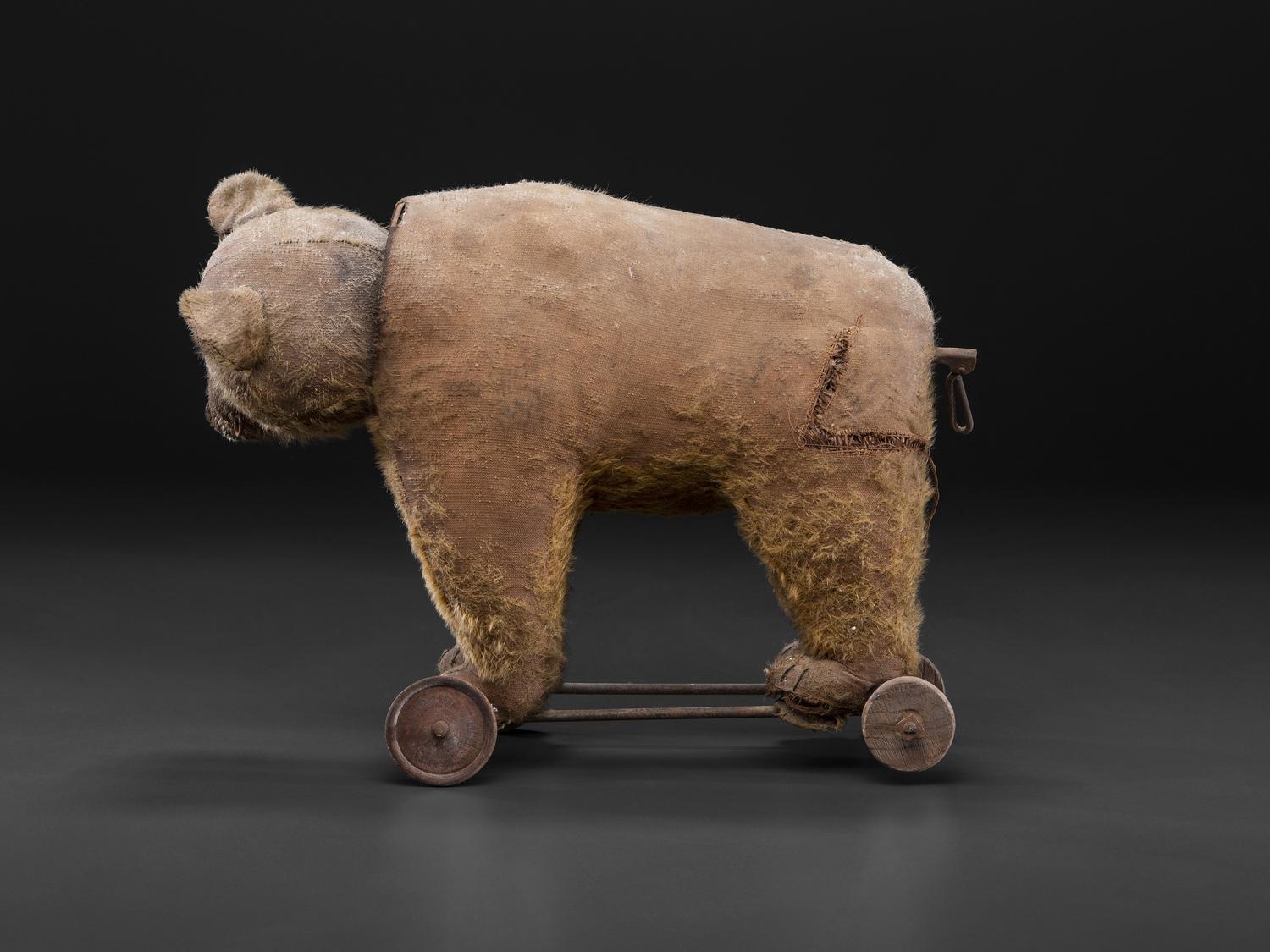 A Stuffed Bear Pull Toy with Rotating Head and Glass Eyes