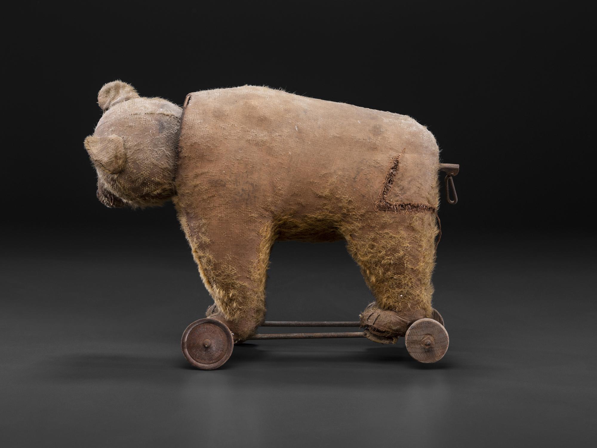 A Stuffed Bear Pull Toy with Rotating Head and Glass Eyes