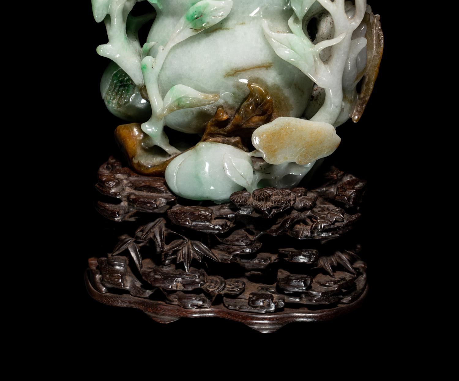 A Chinese Apple Green and Russet Jadeite Carving of Buddha's Hand Citron