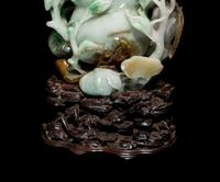 A Chinese Apple Green and Russet Jadeite Carving of Buddha's Hand Citron