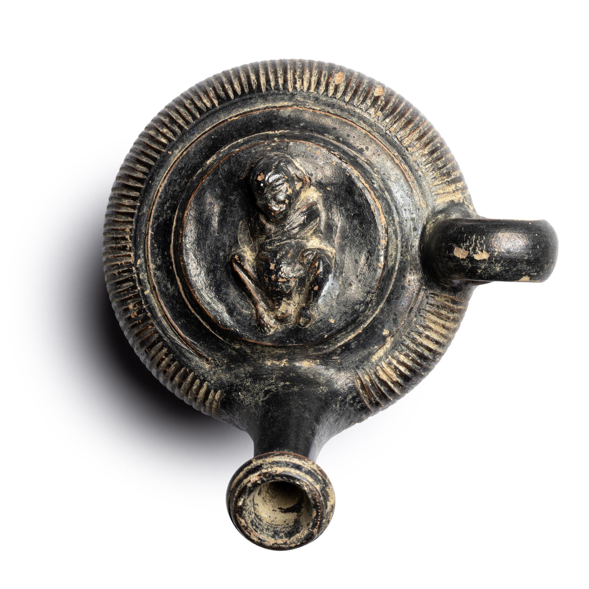 A Campanian Black-Glazed Guttus with a Grotesque