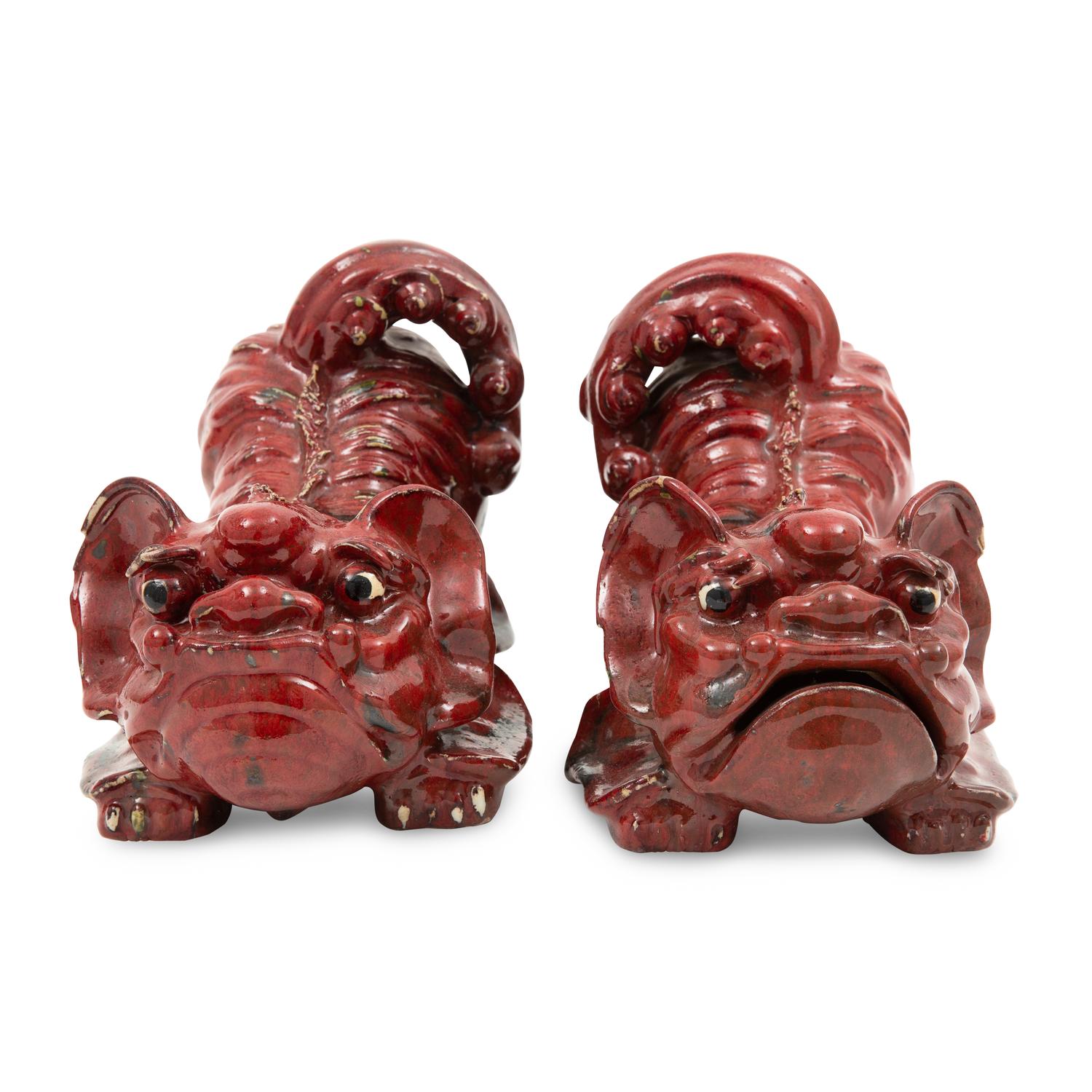 A Pair of Sang de Boeuf Glazed Earthenware Models of Guardian Lions