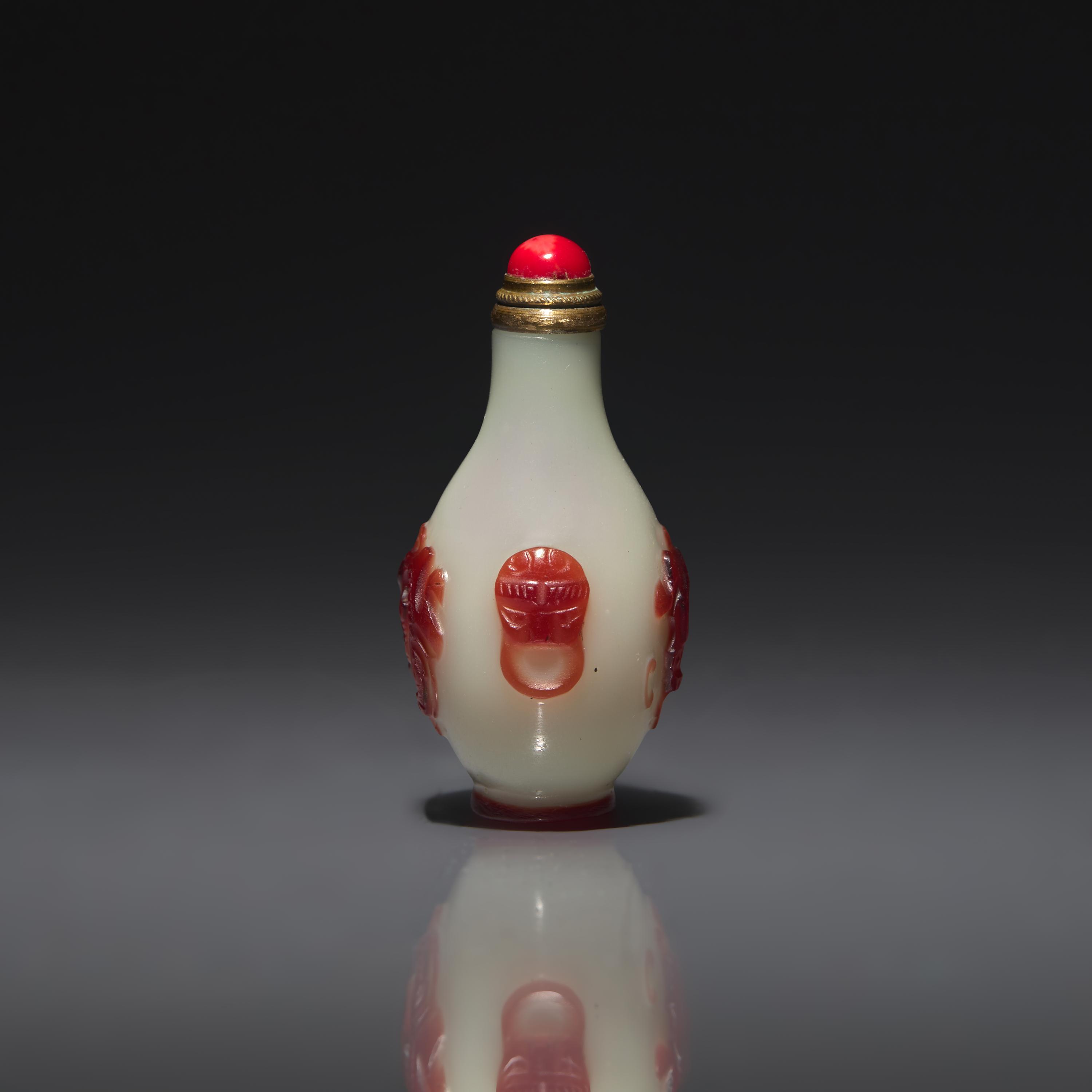 A Chinese Miniature Red-Overlaid Opaline Glass Snuff Bottle, Circa 1750-1820 1750-1820年 涅白地套寶石紅料螭龍紋小鼻烟壺