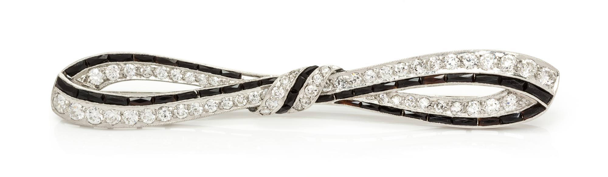 An Art Deco Platinum, Diamond and Onyx Bar Brooch, 5.80 dwts.