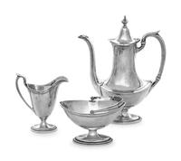 comprising a coffee pot, creamer and sugar.