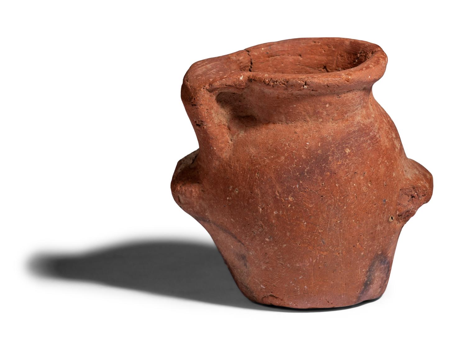An Egyptian Terracotta Jar with the Head of Bes