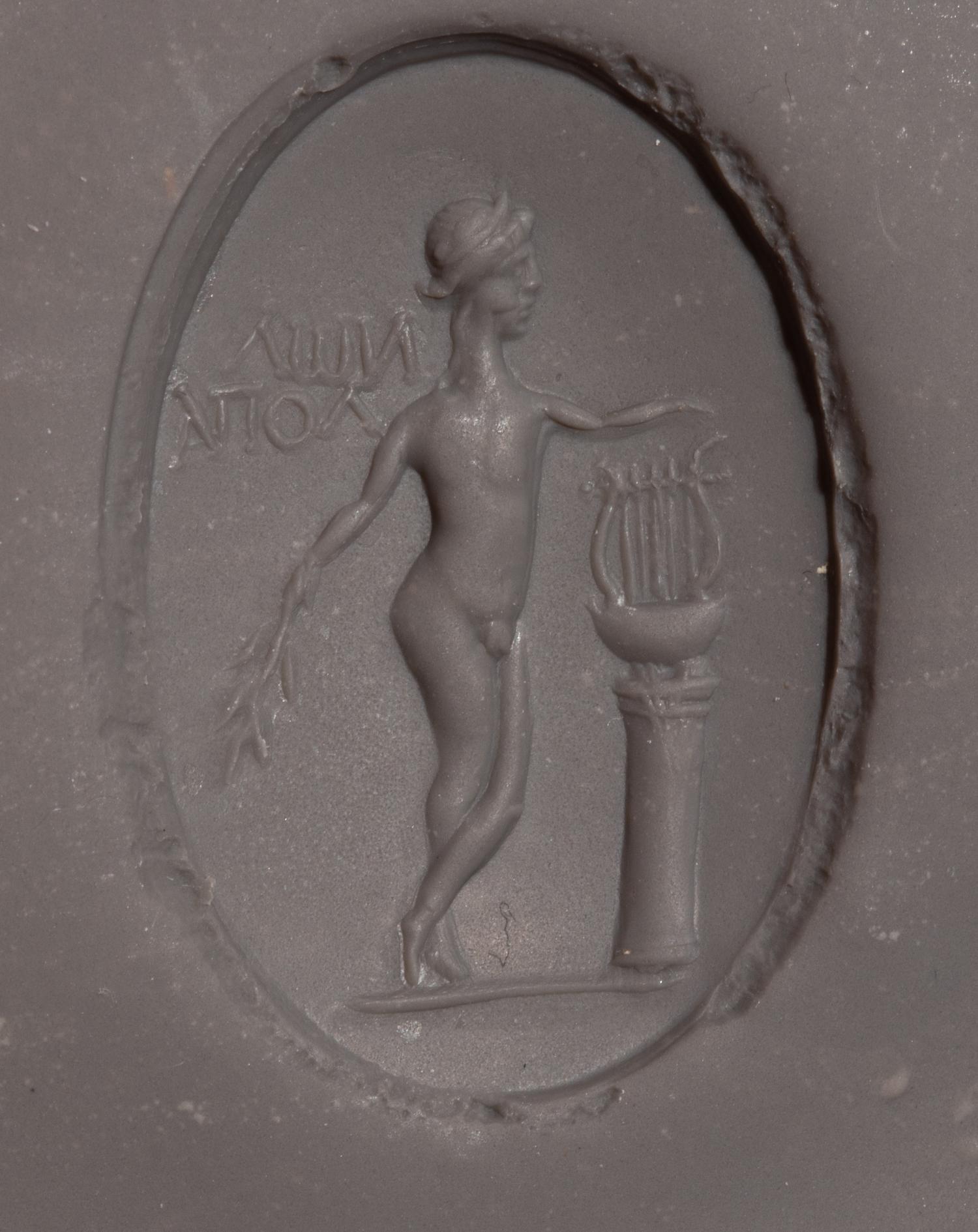 A Roman Copper Alloy and Chalcedony Finger Ring with the God Apollo