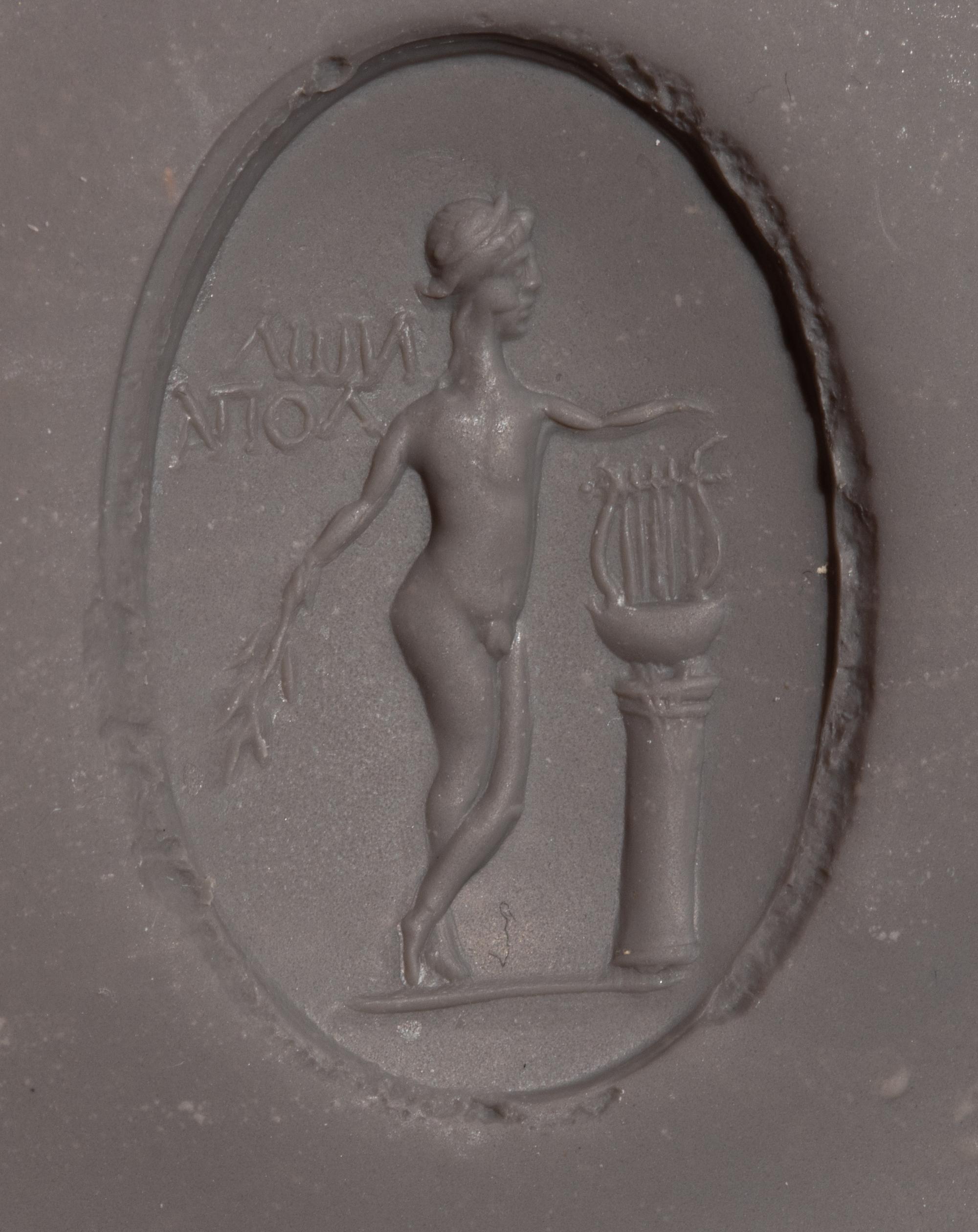 A Roman Copper Alloy and Chalcedony Finger Ring with the God Apollo