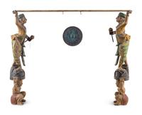 A Pair of Southeast Asian Carved and Polychrome Decorated Figures with a Gong