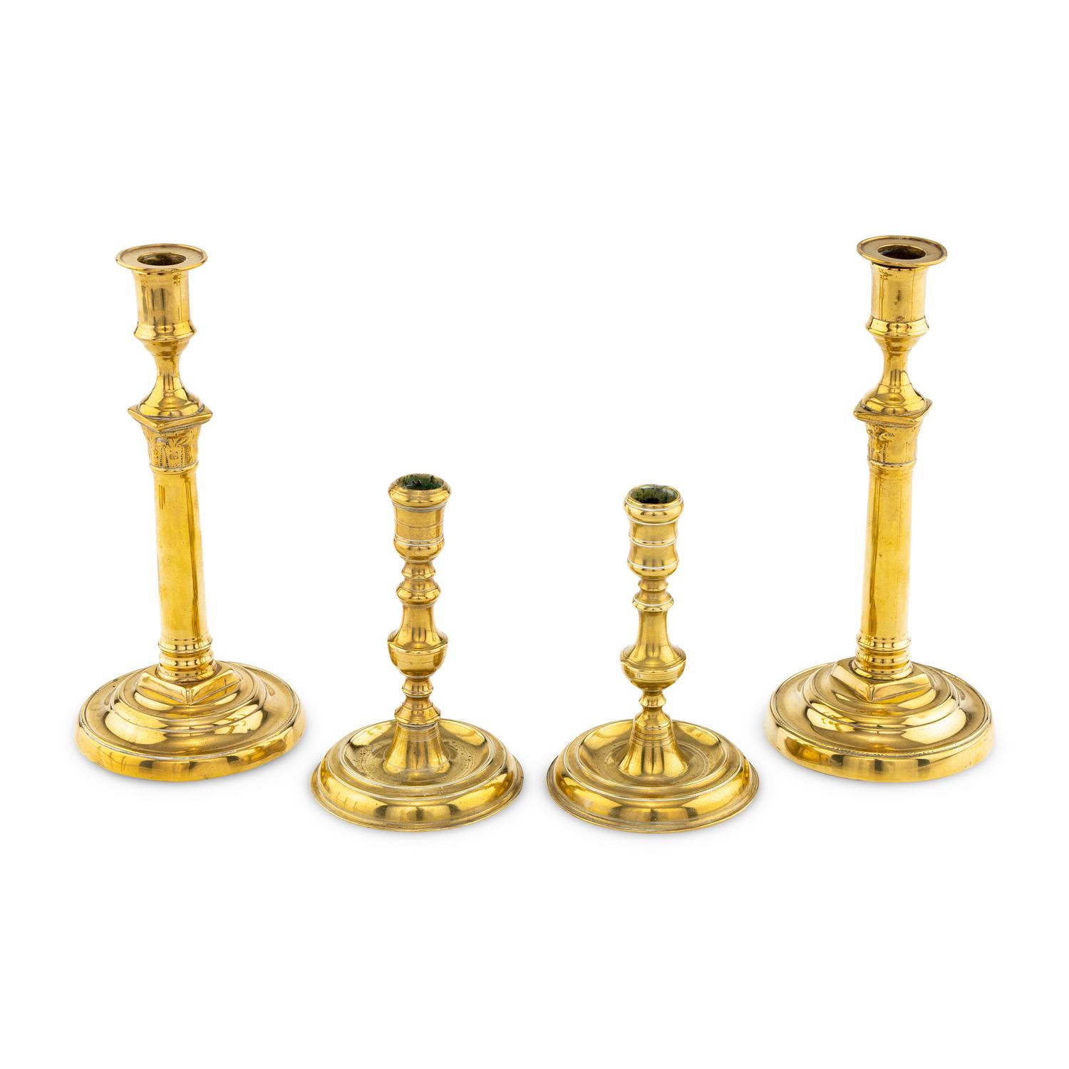 A Collection of Two Pairs of Brass Candlesticks