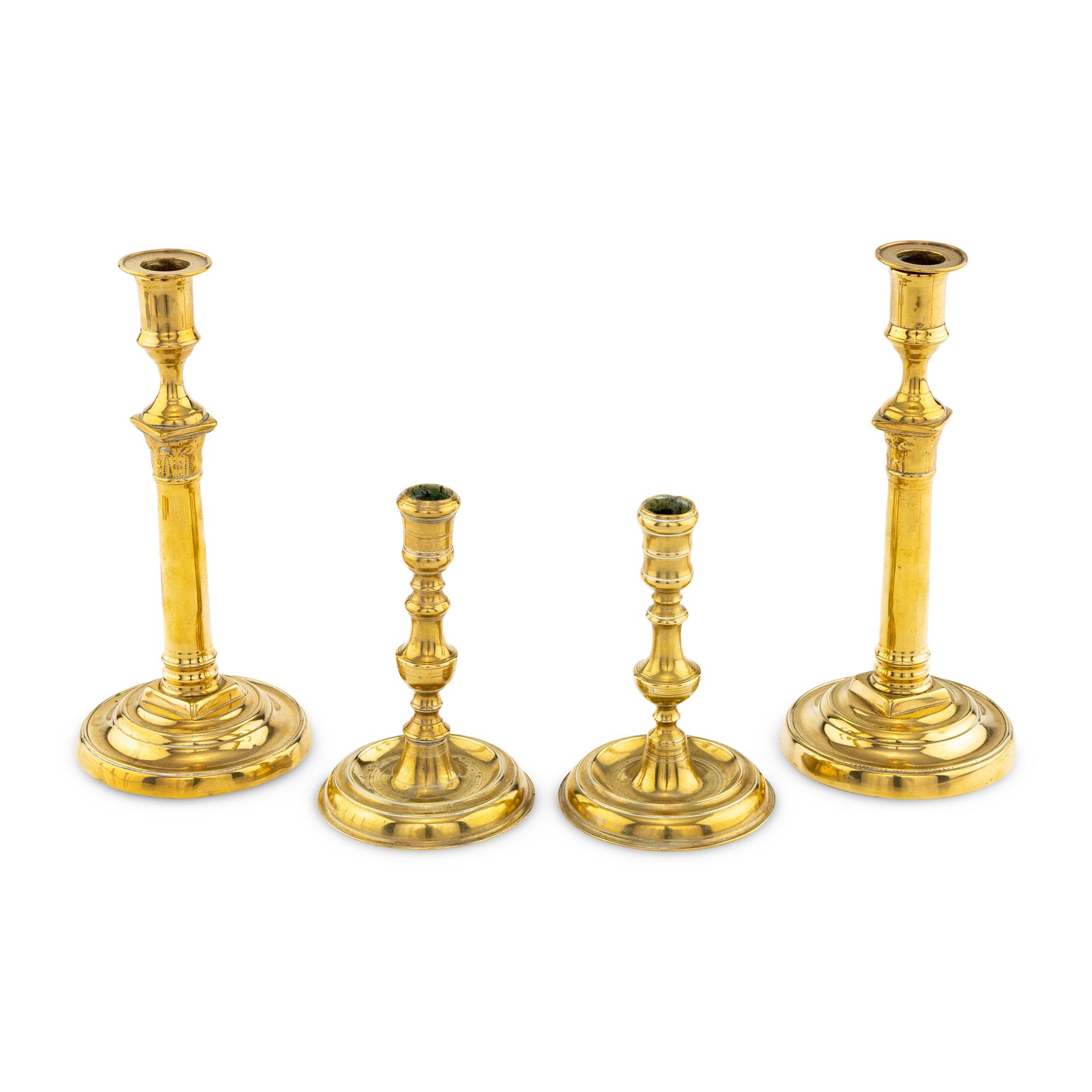 A Collection of Two Pairs of Brass Candlesticks