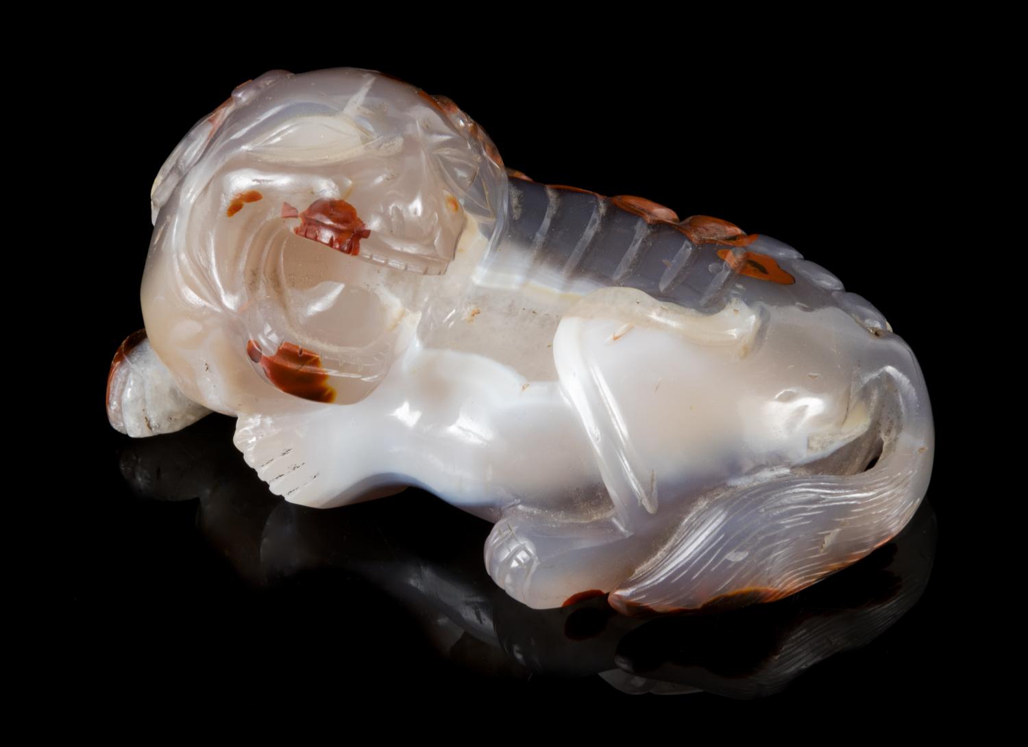 A Chinese Carved Agate Figure of a Recumbent Fu Lion Length 5 1/4 inches. — LATE 19TH/20TH CENTURY