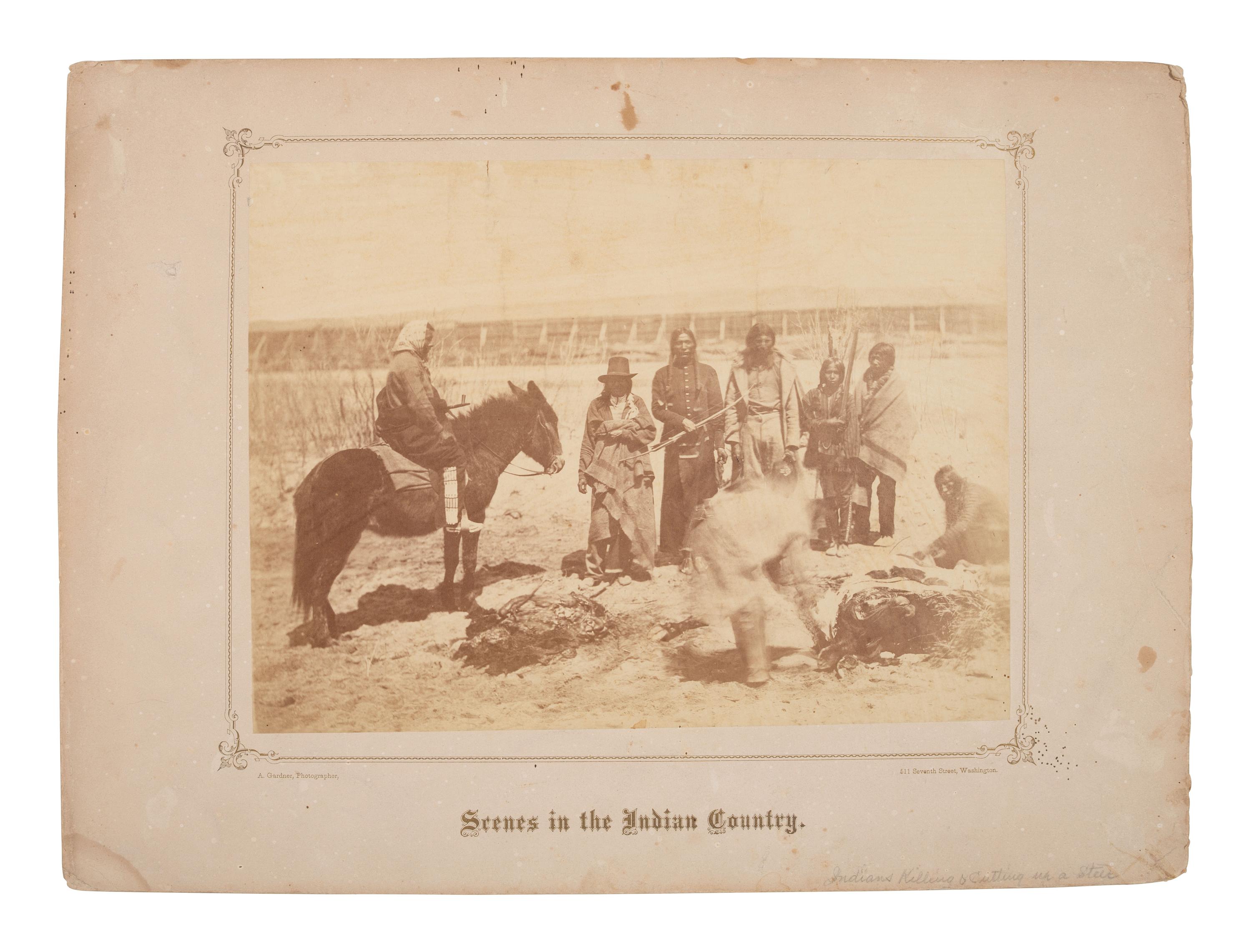 GARDNER, Alexander (1821-1882), photographer. Albumen photograph of members of the Dakota Tribe at the Fort Laramie Council butchering a cow. 1868.