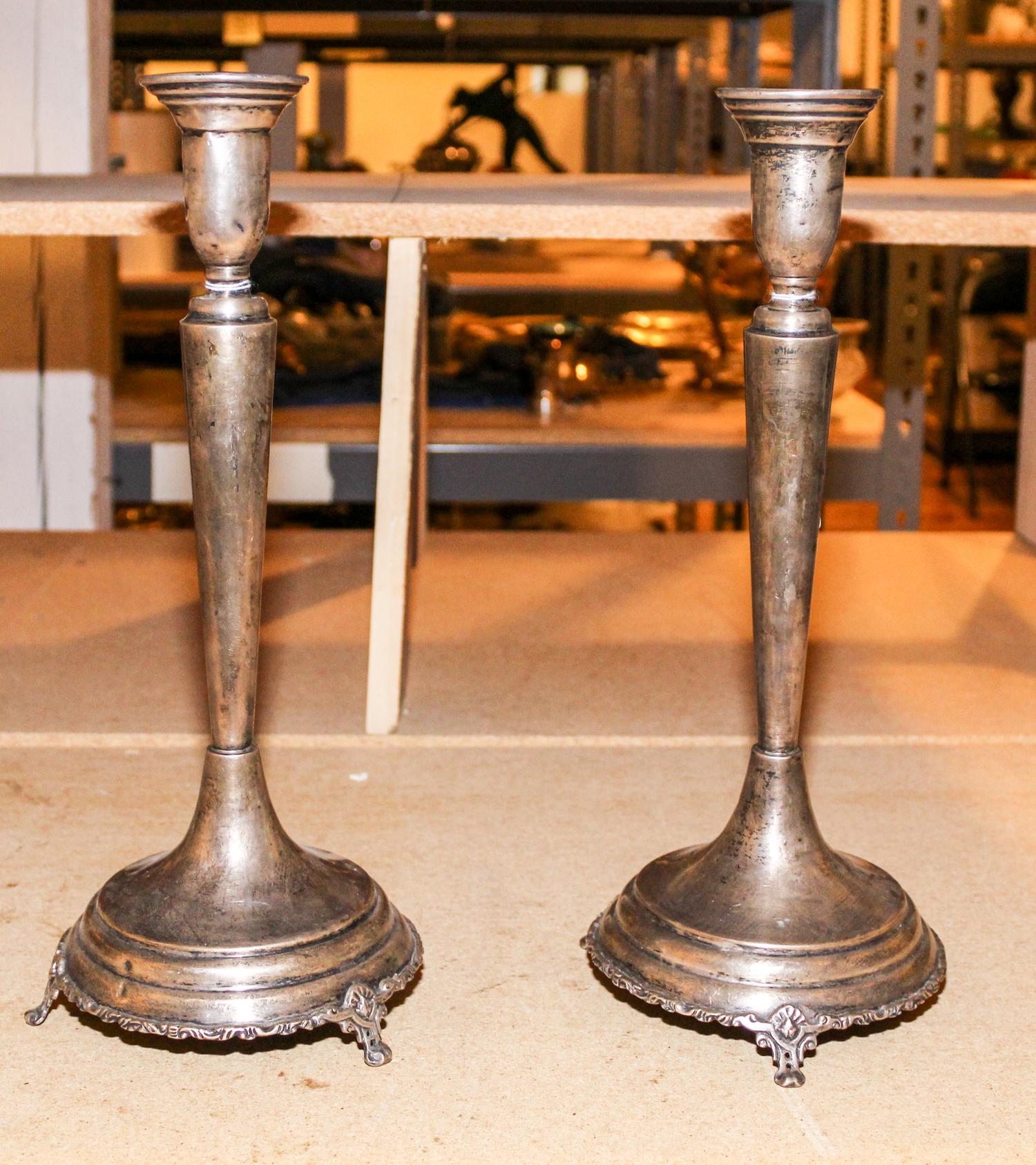 A Pair of Mexican Silver Candlesticks, , having a baluster form cup surmounting a tapering stem and stepped base, raised on three pierc