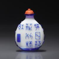 A Chinese Glass Overlay "Lotus" Snuff Bottle, Qing Dynasty, Circa 1750-1795 — 1750-1795年 涅白地套寶石藍料荷花紋鼻煙壺