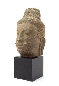 A Southeast Asian Stone Head of a Bodhisattva 17TH CENTURY OR EARLIER Height overall 18 inches. — 17TH CENTURY OR EARLIER