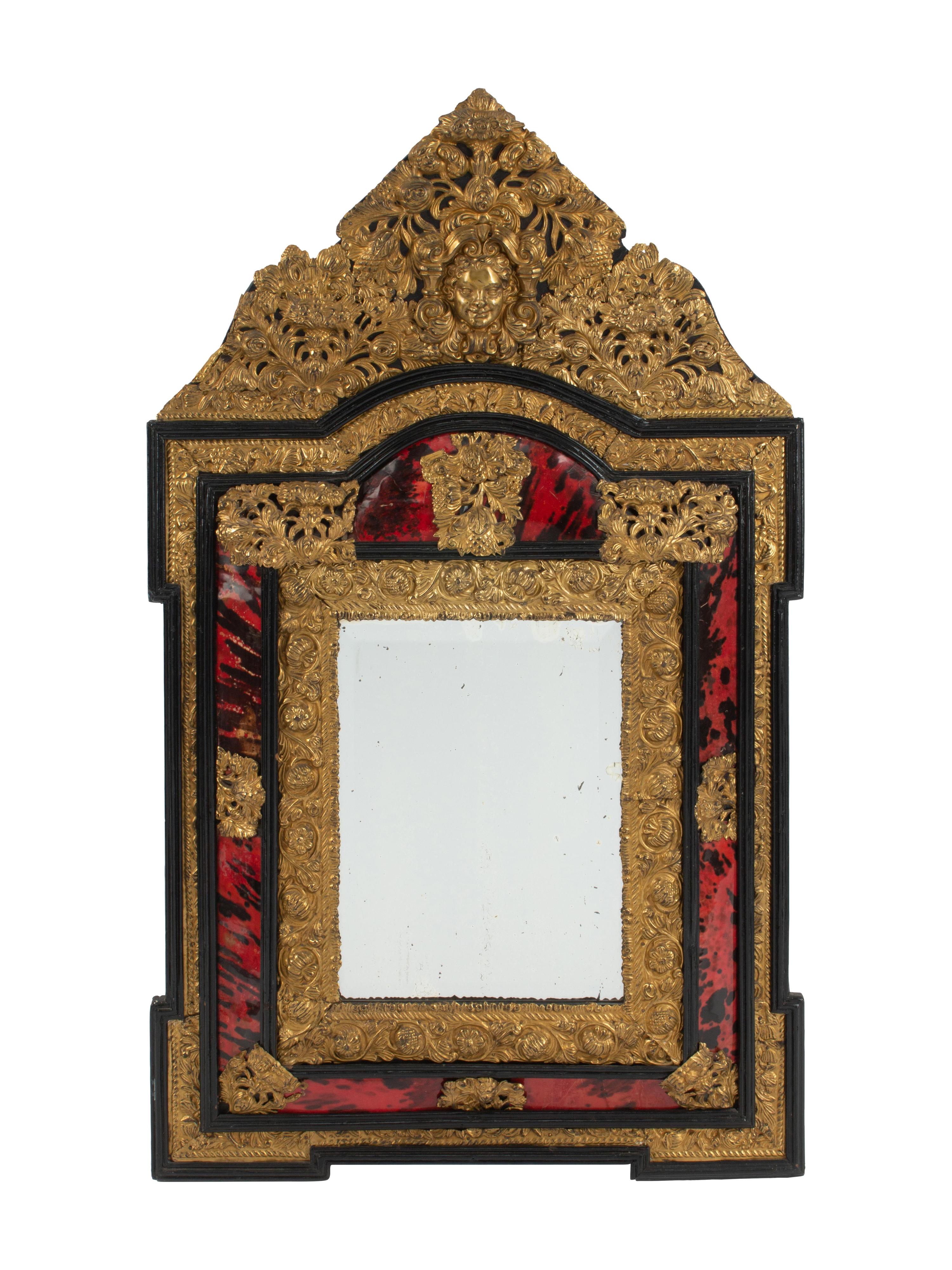 A Flemish Baroque Style Parcel Ebonized and Repoussé Brass Mirror