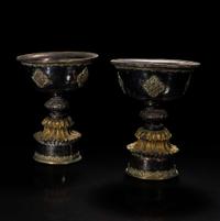 A pair of Tibetan or Mongolian parcel gilt butter lamps and a gilt repoussé mask 鎏金兽面铜牌饰和鎏金灯盏一对