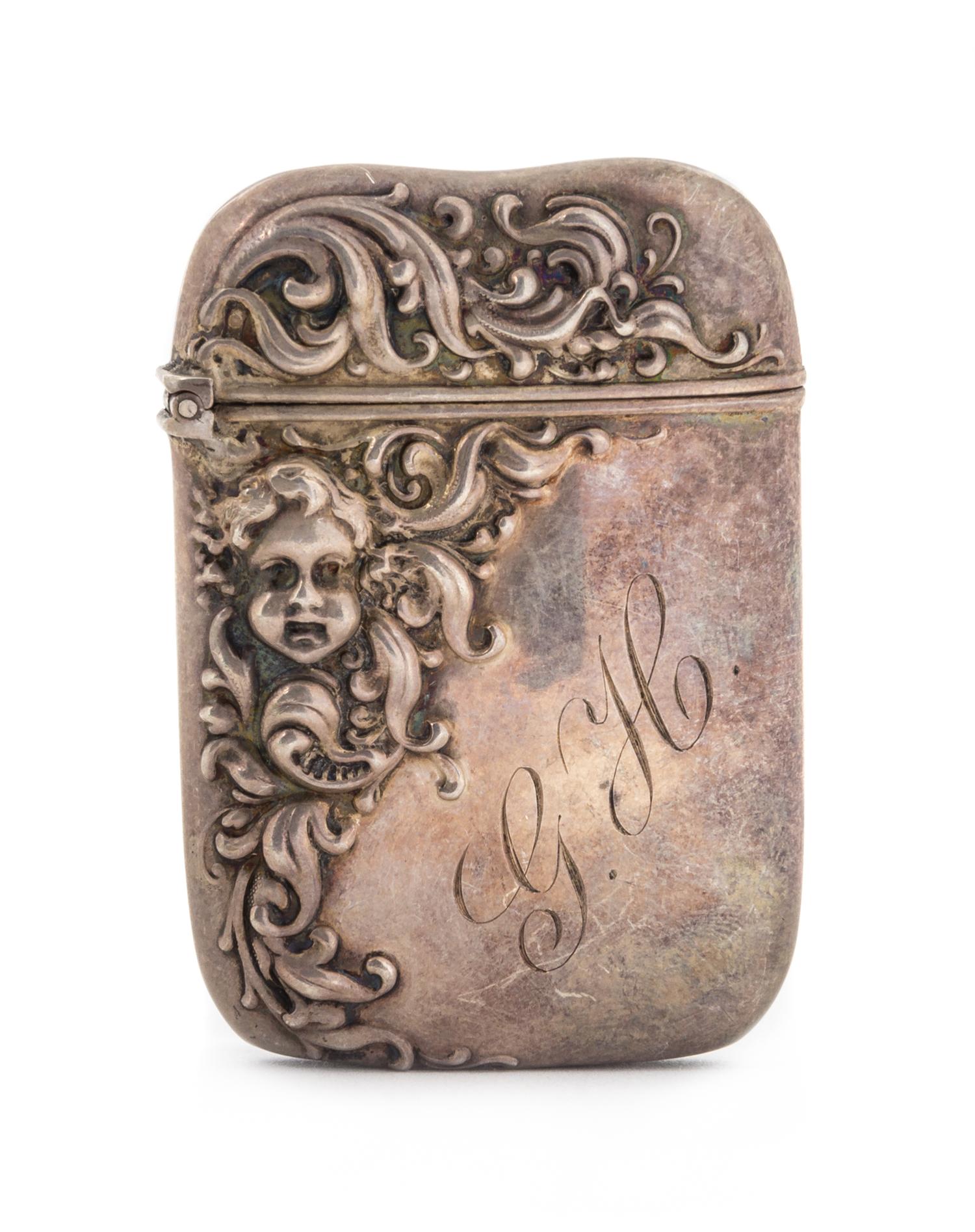 An American Silver Vesta Case, Possibly John Hasselbring, Brooklyn, NY, the body decorated with repousse foliate volutes and a putti ma