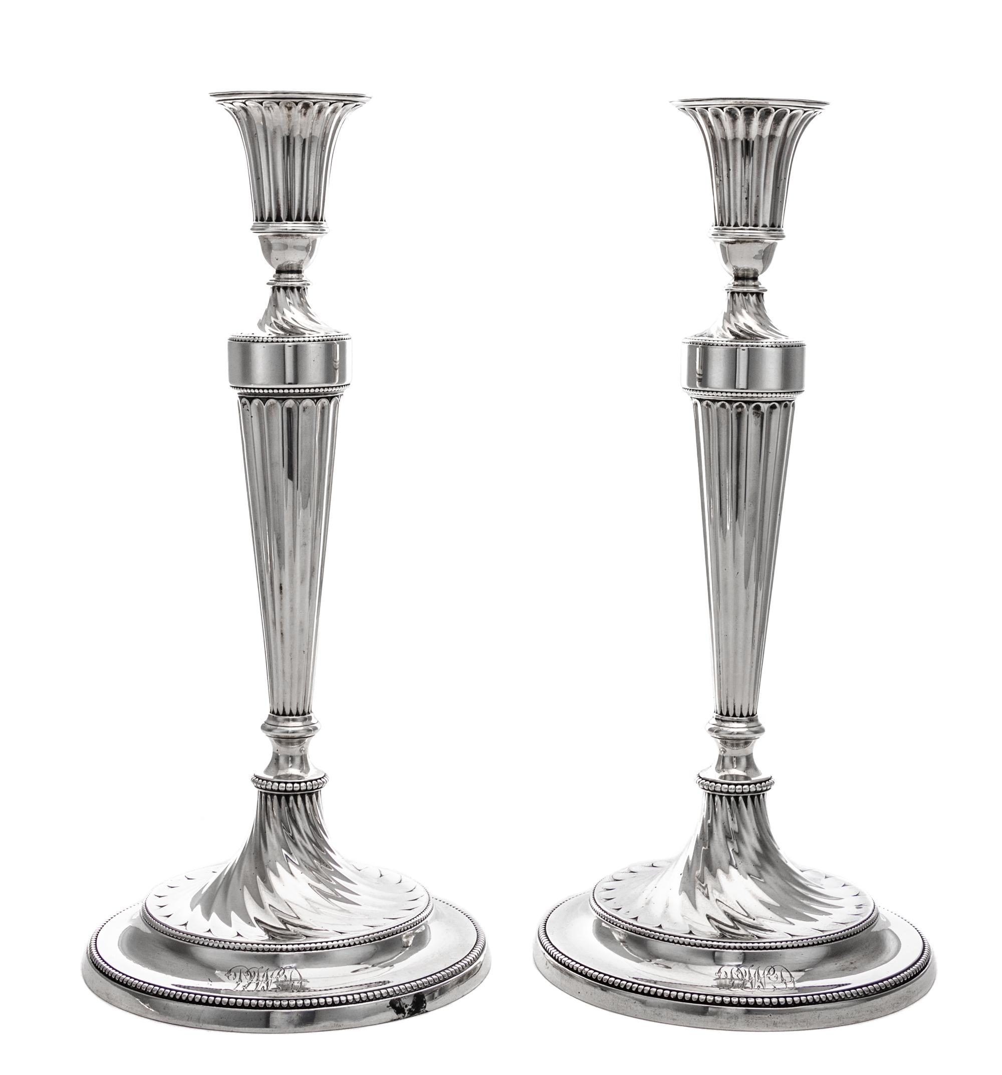 A Pair of George III Silver Candlesticks, John Schofield, London, 1781-2, the fluted candle cup above the fluted tapering stem ending i