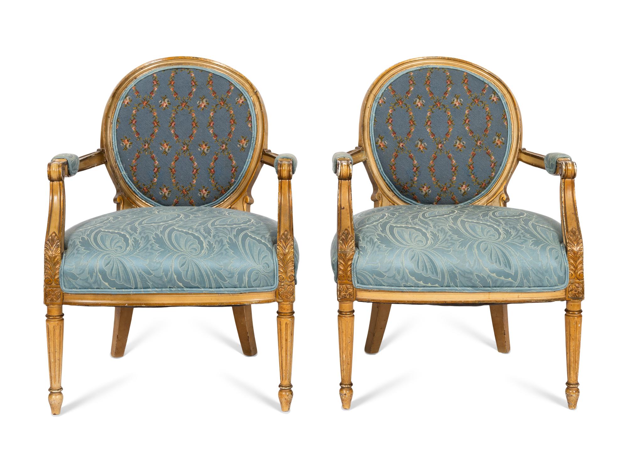 A Pair of Louis XVI Style Cream-Painted and Parcel Gilt Fauteuils with Needlepoint Backs