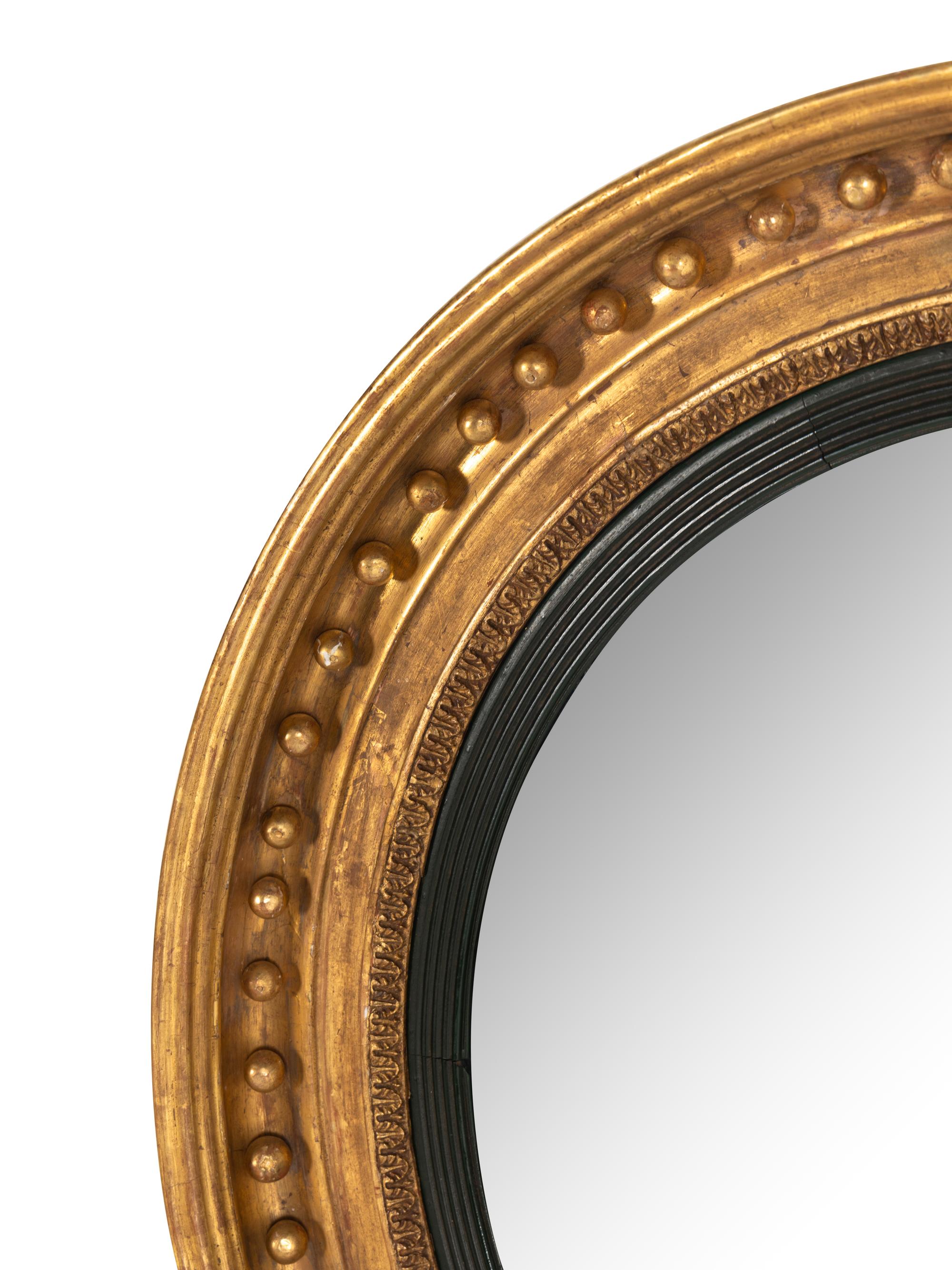 A Pair of Regency Carved Giltwood Convex Wall Mirrors