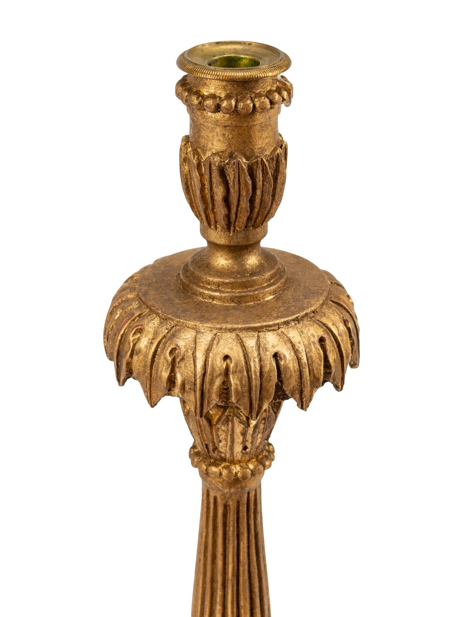 A Pair of Italian Neoclassical Carved and Parcel Gilt Candlesticks