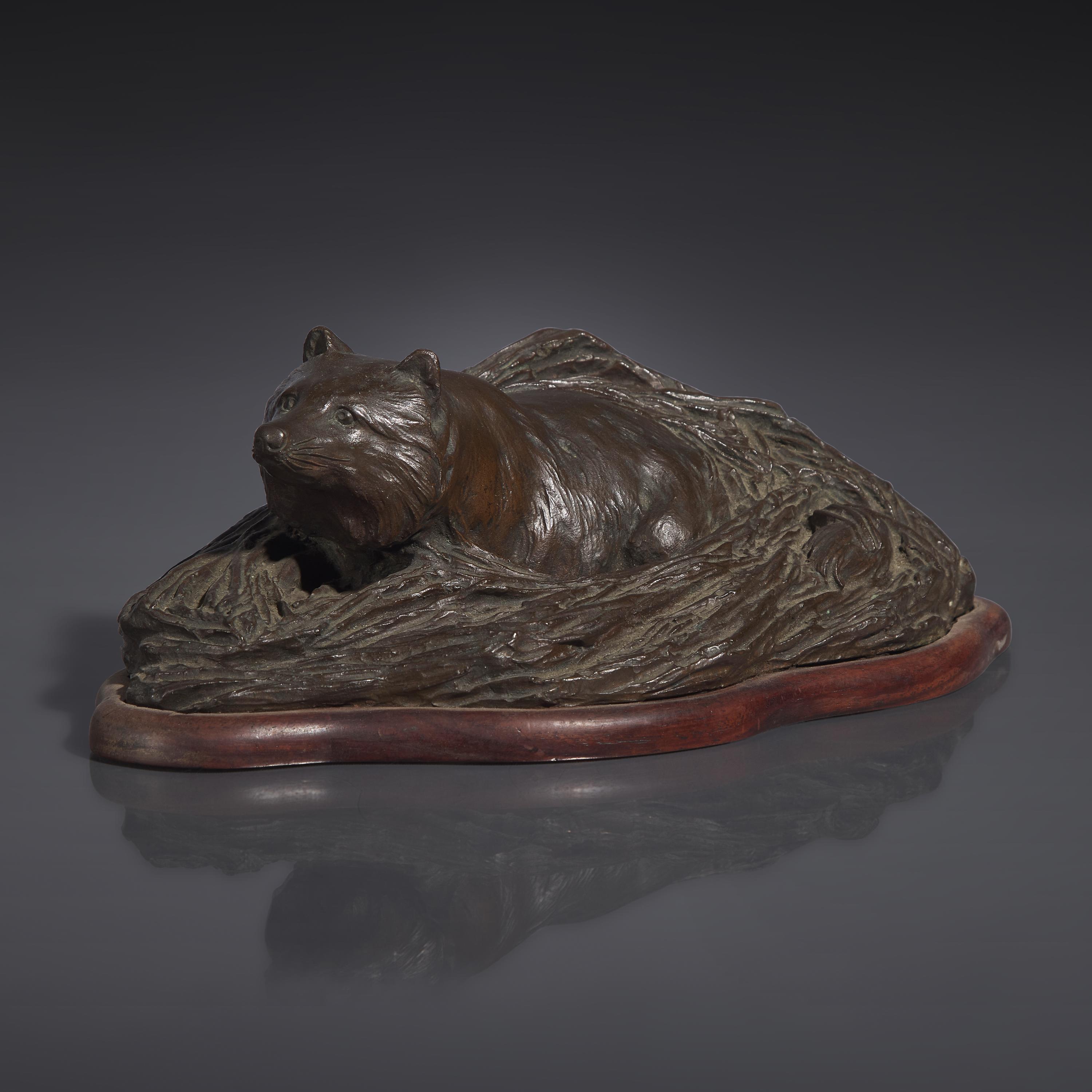 A Japanese Patinated Bronze Figure of a Tanuki in Grasses, Meiji/Taisho Period, The Maruki Co., Tokyo — 日本明治/大正時代 “丸喜製銅”銅狸貓置物