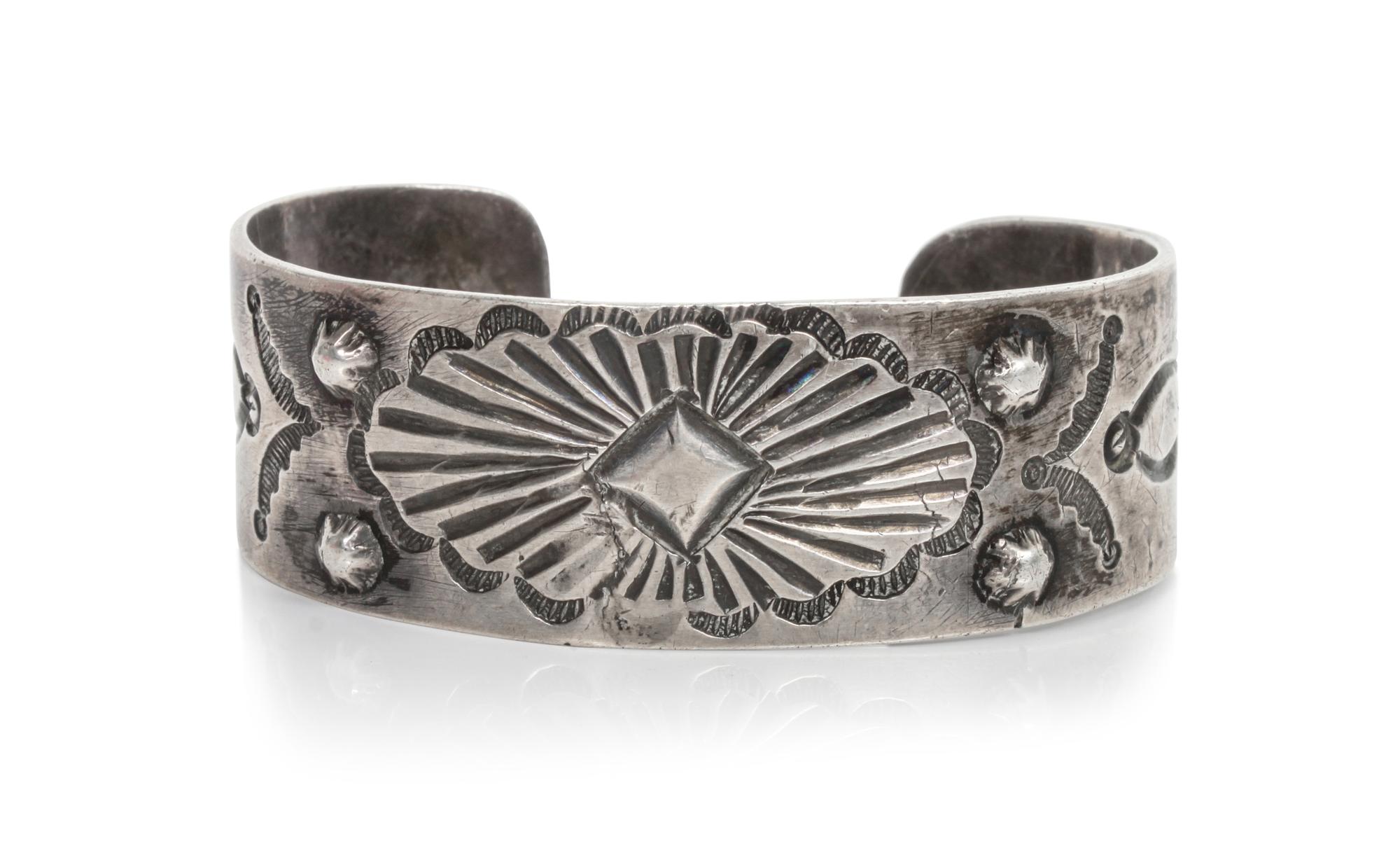 An Early Repousse and Stamped Silver Bracelet Length 5 3/4 x opening 1 x width 7/8 inches. — CIRCA 1920