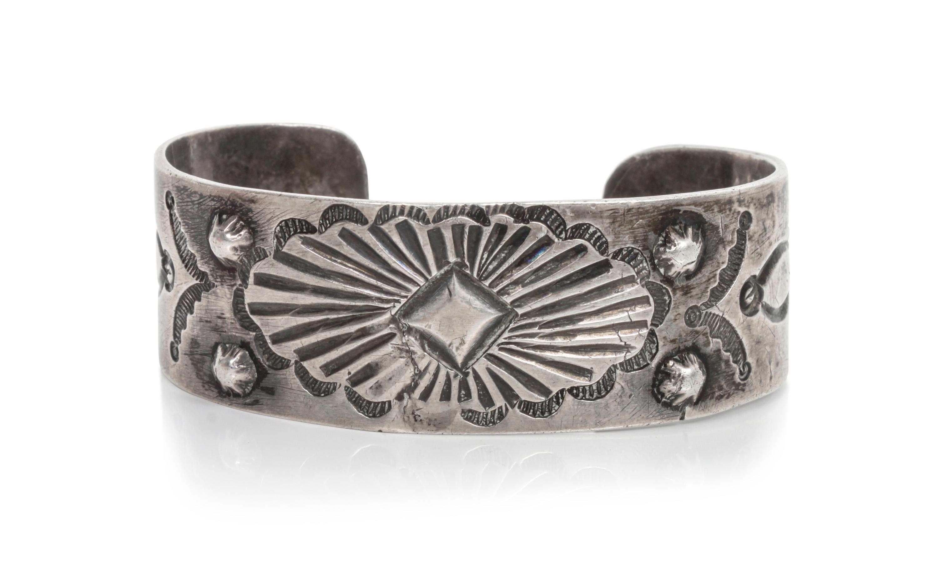 An Early Repousse and Stamped Silver Bracelet Length 5 3/4 x opening 1 x width 7/8 inches. — CIRCA 1920