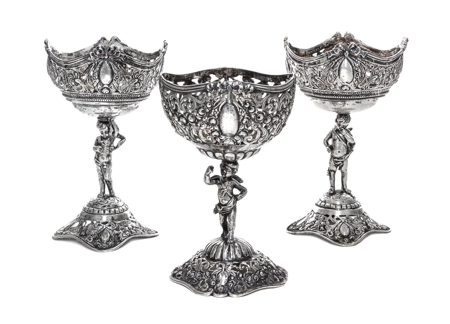 A Set of Three German Silver Goblets, 19th/20th Century, each pierced bowl with four vacant cartouches, raised on a figural stem in the