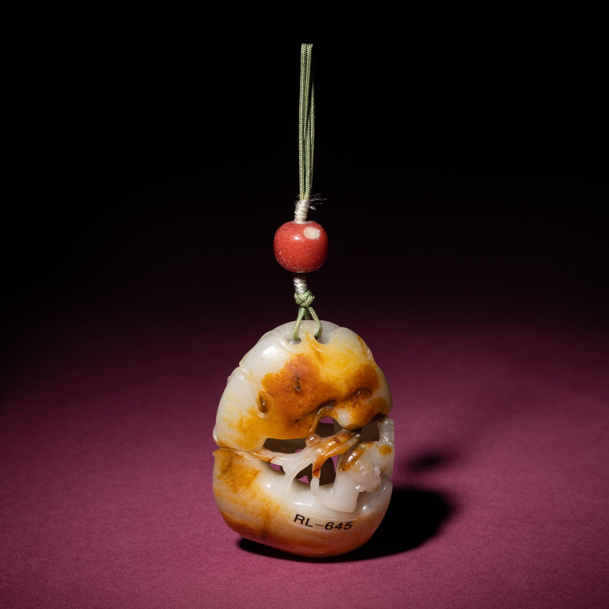 A Chinese Russet and White Jade Reticulated Pendant, 18th/19th Century — 清中期 白玉帶皮鏤雕石榴荔枝佩