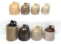 A Collection of Eight Stoneware Whiskey Jugs Height of tallest 16 1/2 inches.