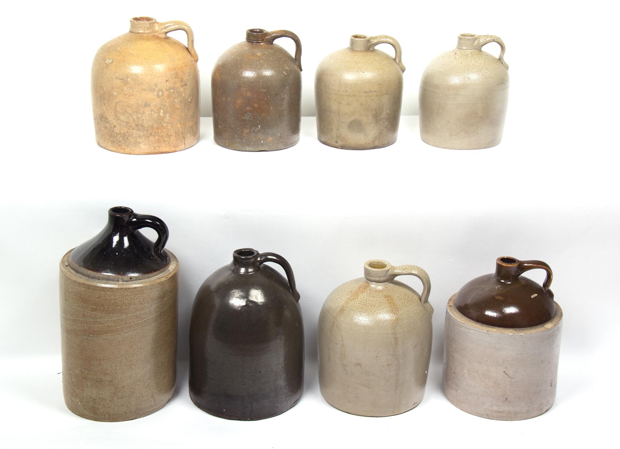 A Collection of Eight Stoneware Whiskey Jugs Height of tallest 16 1/2 inches.