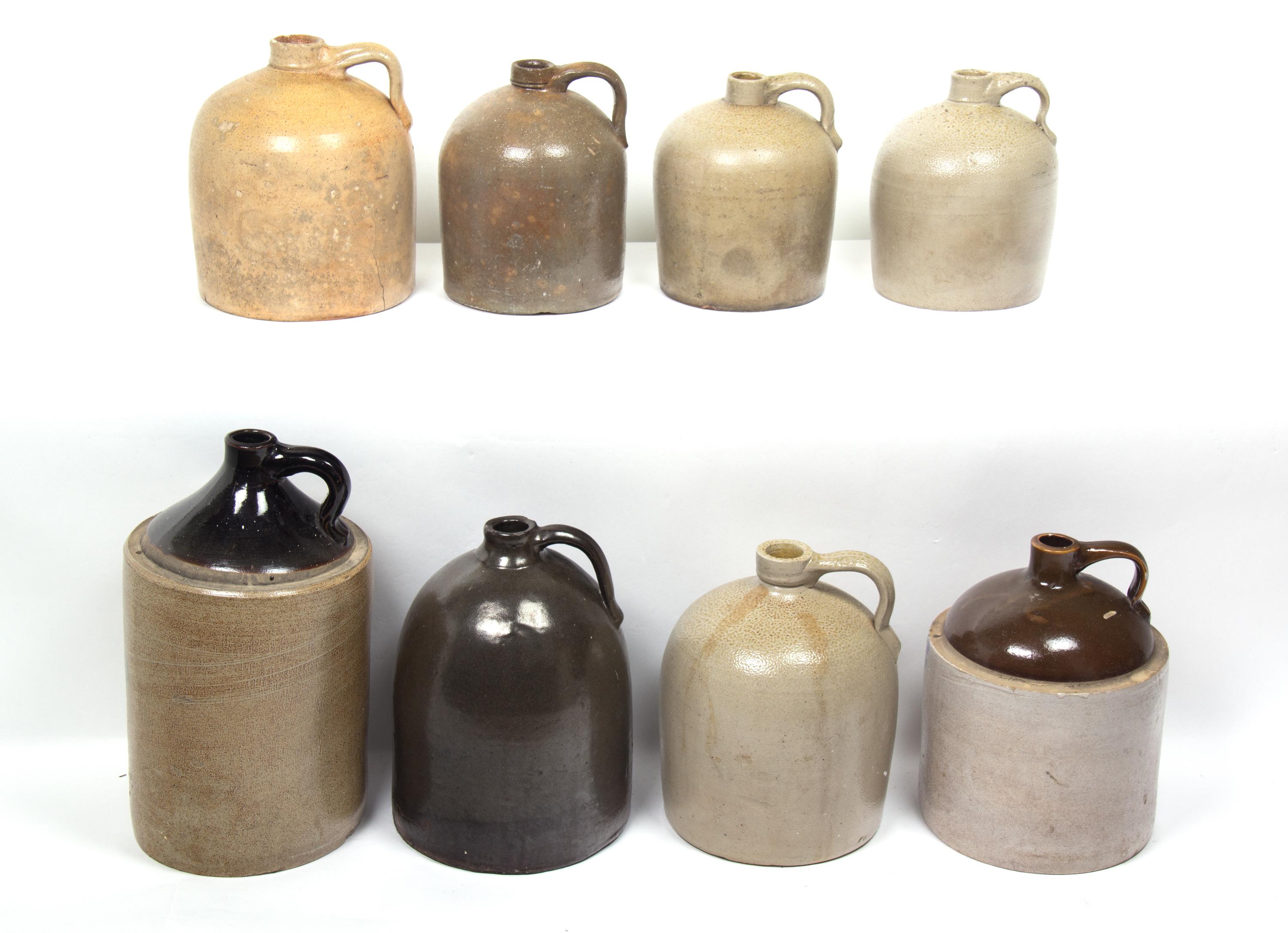 A Collection of Eight Stoneware Whiskey Jugs Height of tallest 16 1/2 inches.
