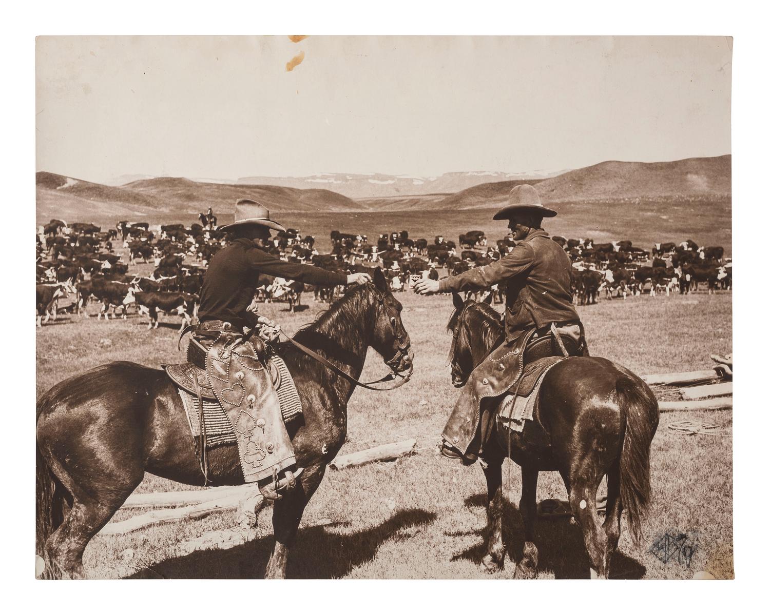 [WESTERN AMERICANA]. BELDEN, Charles J. (1888-1963), photographer. Silver gelatin photograph of cowboys sharing a pack of Camel "Tailor Made" cigarettes. Pitchfork Ranch, WY, ca 1920s-1930s.
