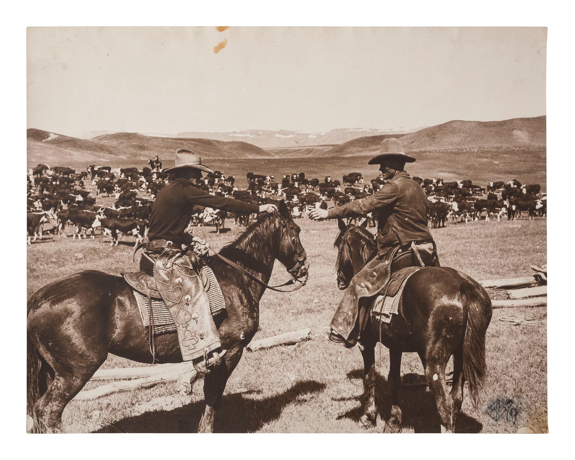 [WESTERN AMERICANA]. BELDEN, Charles J. (1888-1963), photographer. Silver gelatin photograph of cowboys sharing a pack of Camel "Tailor Made" cigarettes. Pitchfork Ranch, WY, ca 1920s-1930s.