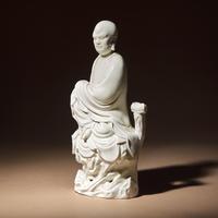 A Chinese Blanc-de-Chine Porcelain Seated Figure of Damo with 'He Chaozong' Mark, Qing Dynasty — 清 何朝宗款“隻履西歸”德化白瓷達摩坐像