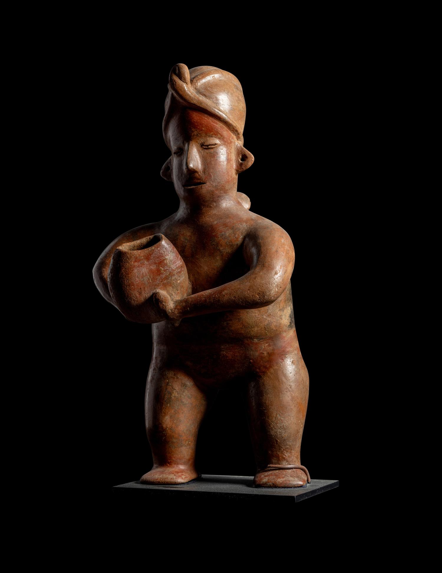 A Colima Standing Figure Holding a Pot