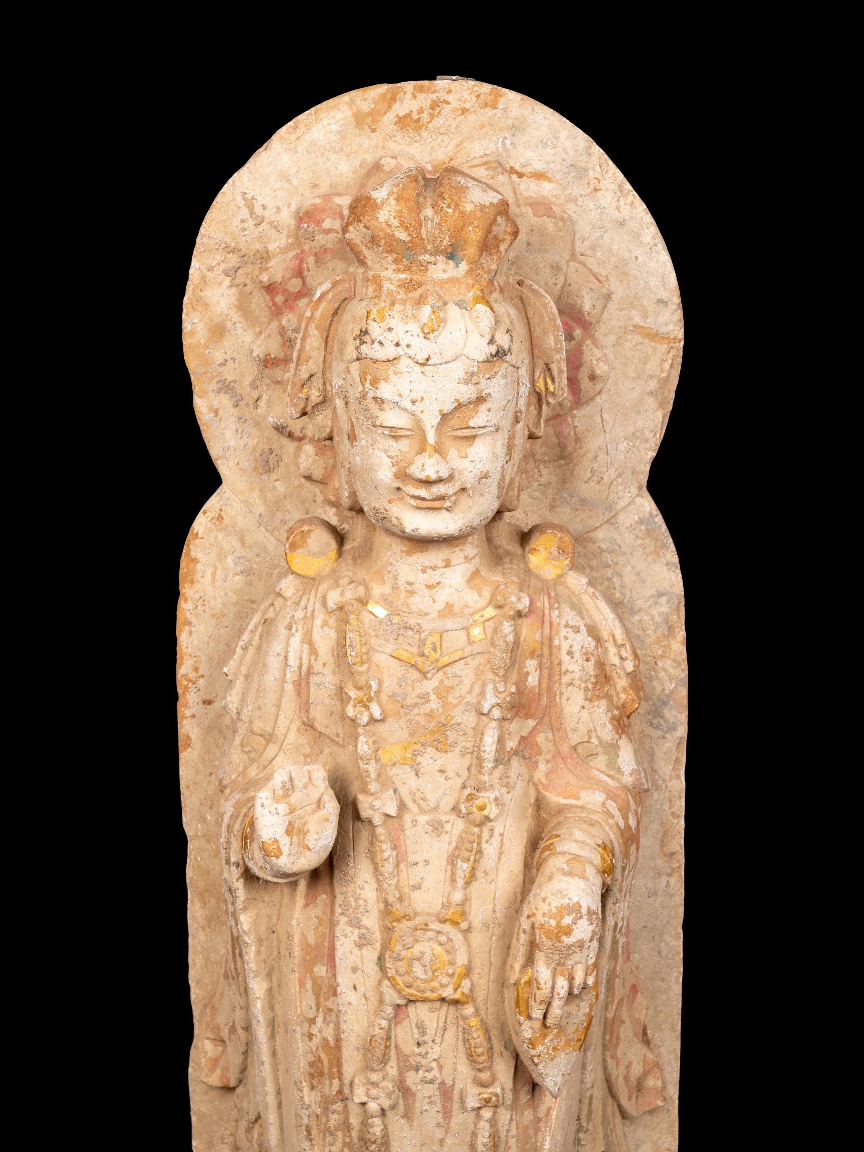 A Chinese Carved Stone Standing Buddha with Remnants of Gilt on Lotus-Form Base