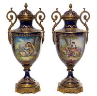 A Pair of Sevres Style Gilt Bronze Mounted Porcelain Urns Height 15 3/8 inches.