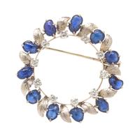 An 18 Karat White Gold, Sapphire and Diamond Wreath Motif Brooch, 8.10 dwts.