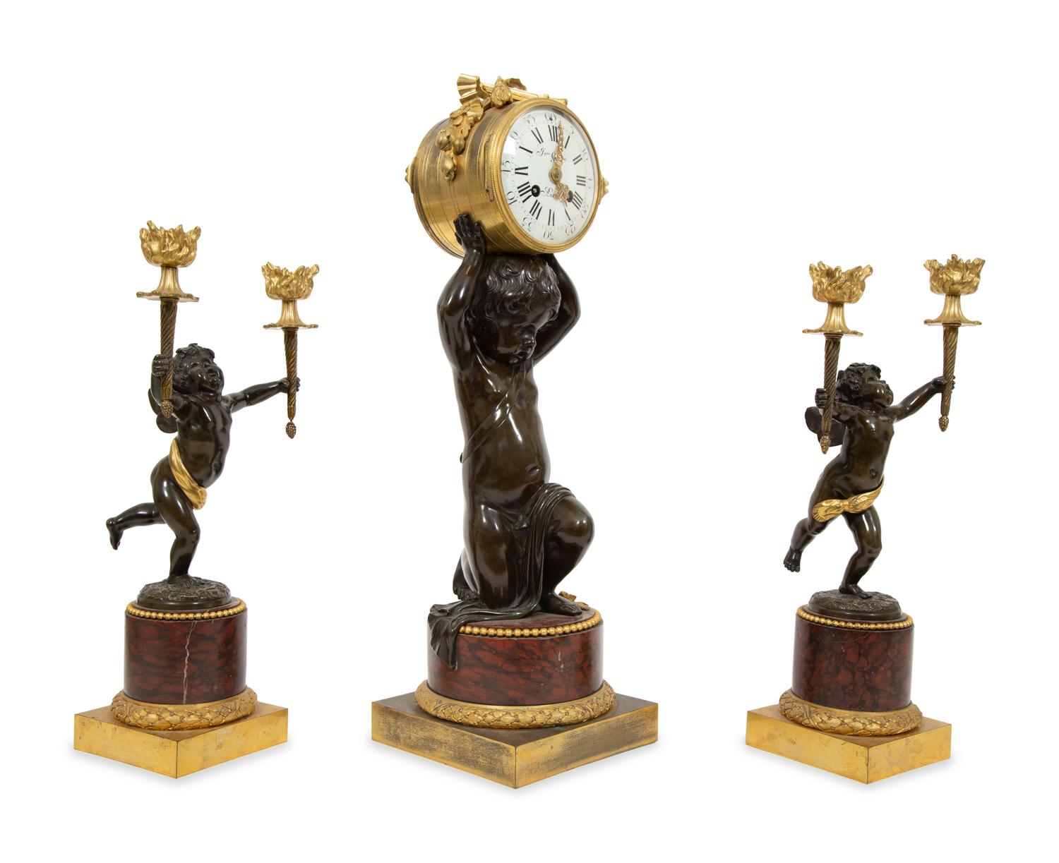 A French Gilt and Patinated Bronze and Rouge Marble Clock Garniture