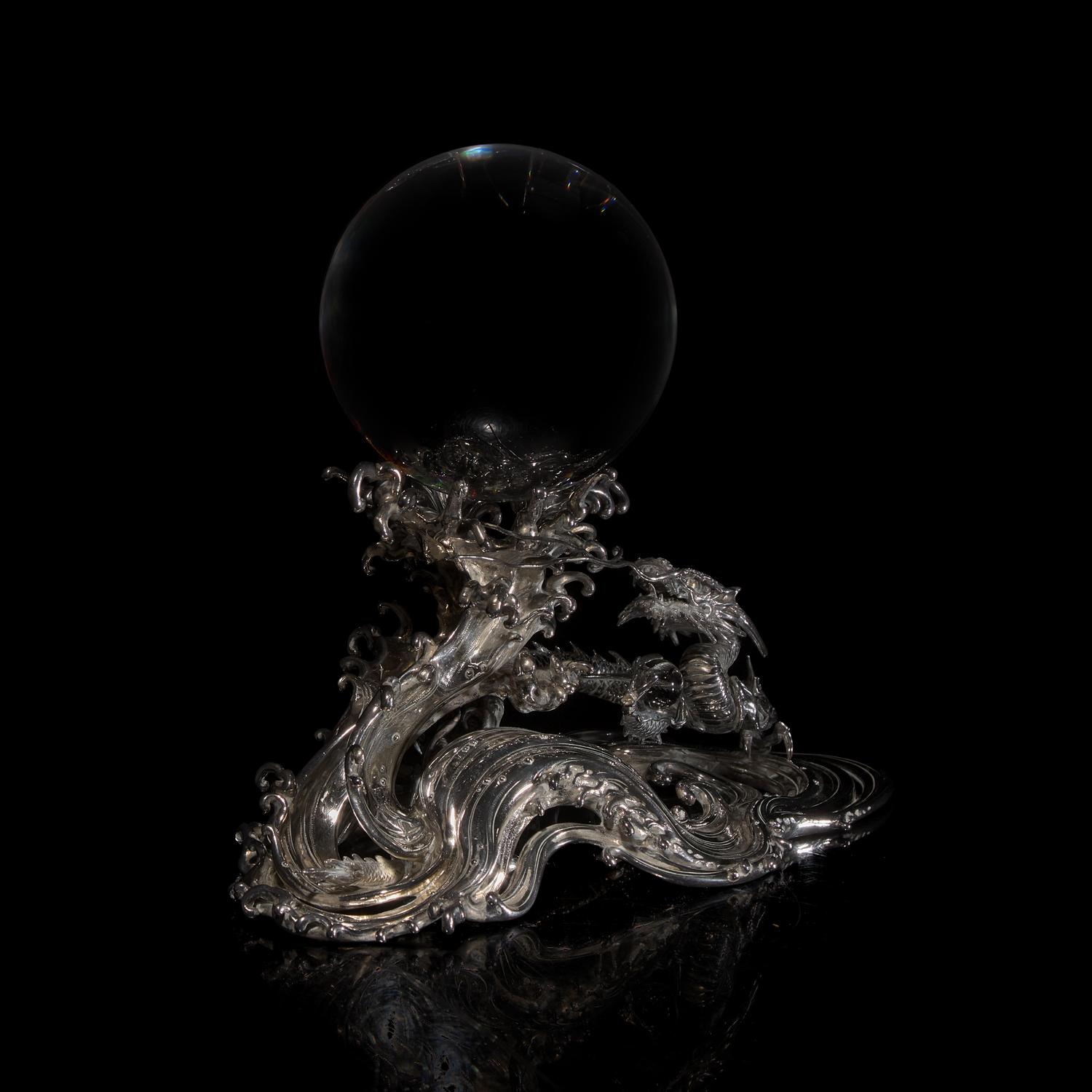 A Japanese Rock Crystal Sphere and Silver 'Dragon and Waves' Stand, Signed Yoshimasa Saku Meiji/Taisho Period 日本明治/大正時期 義正作潮を支配する珠と龍