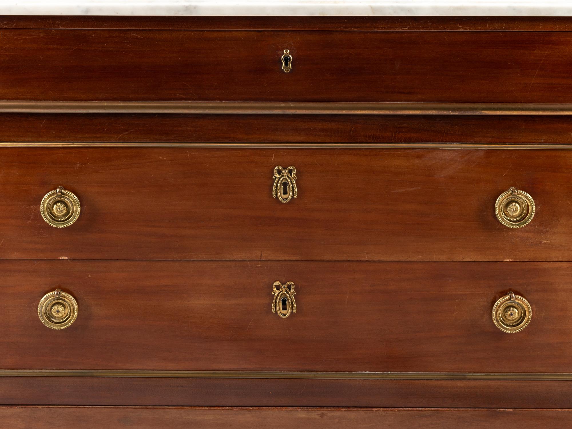 A Louis XVI Style Gilt Bronze Mounted Mahogany Marble-Top Commode