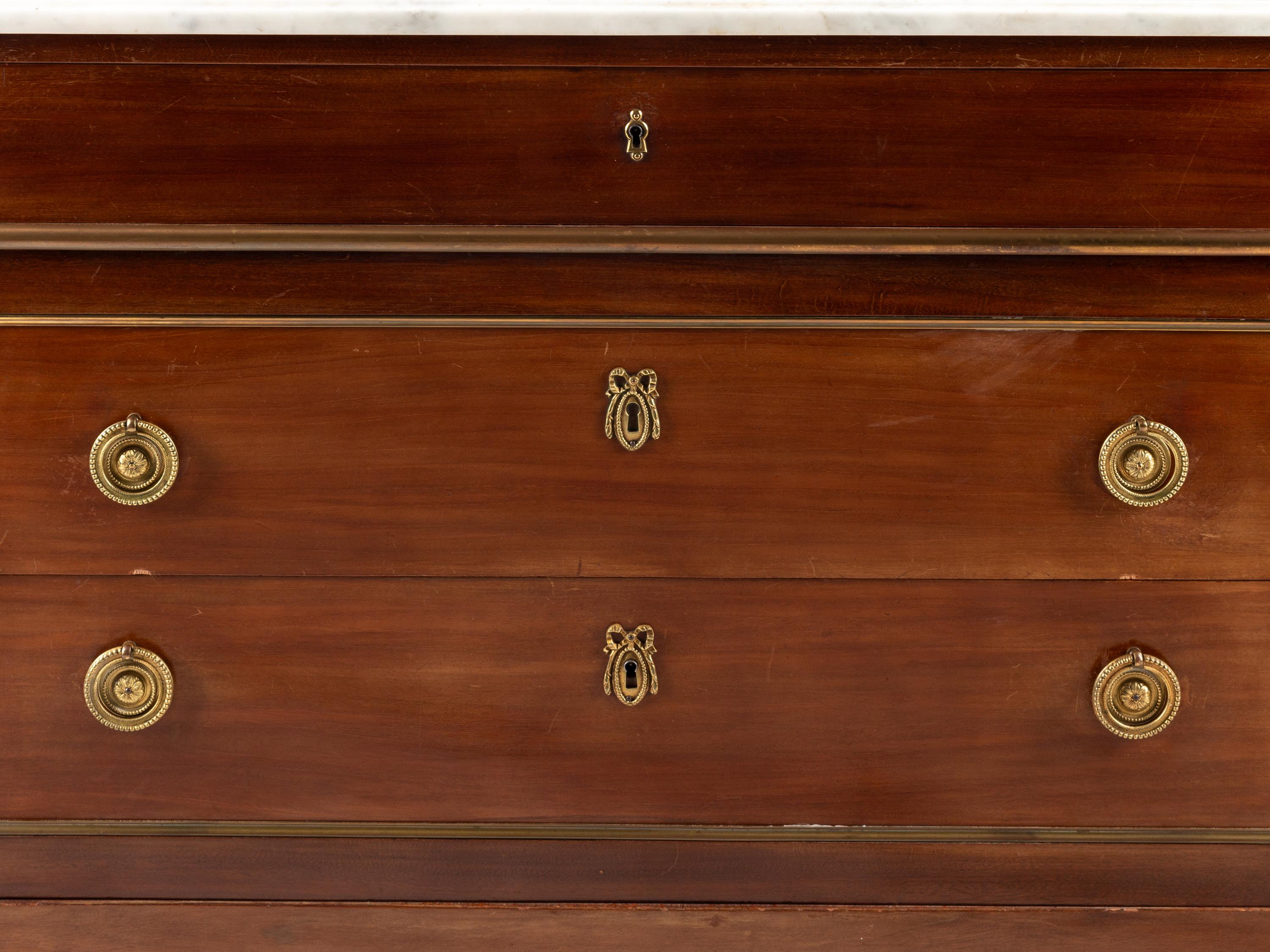 A Louis XVI Style Gilt Bronze Mounted Mahogany Marble-Top Commode
